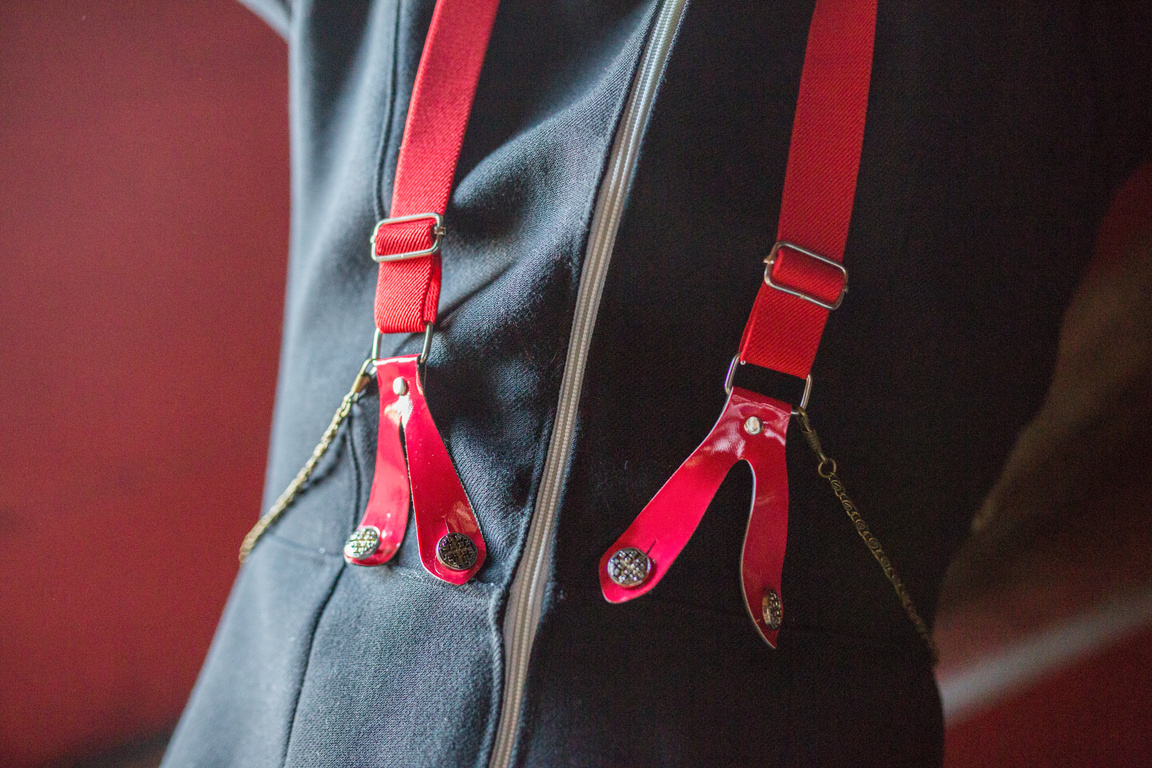 Red fashionable suspenders on black jacket.